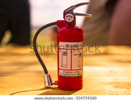 Red fire extinguisher on a wooden table, Concept