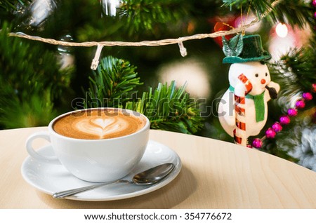Photo of beautiful Christmas light festive, white coffee cup on the wooden table on bokeh background.