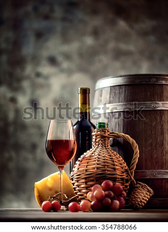 Glass, bottle, carafe of wine and barrel shot with selective focus
