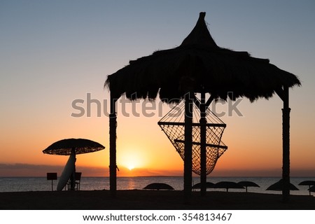 Silhouette of hammock during tropical sunset
