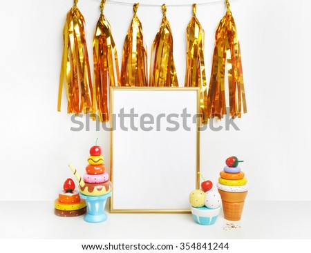 Mockup frame.Gold frame and white wall. Gold tassel and sweet bar. Ice cream, cupcakes, cherry.