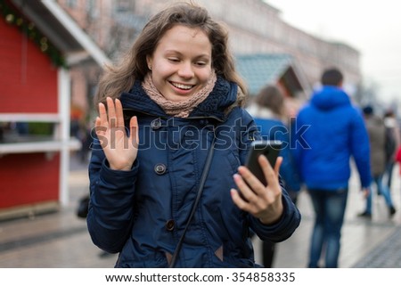young smiling woman says hello speaking by net outdoors