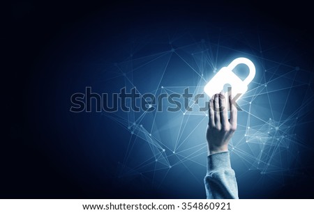 Hand of businessman on dark background with security glowing sign