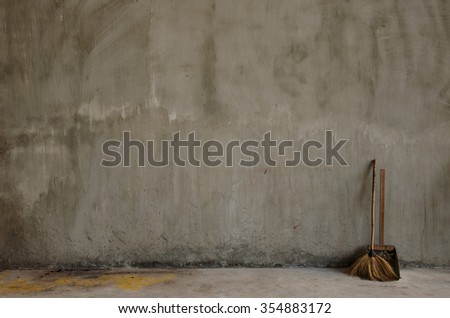 A lonely broom with cement wall