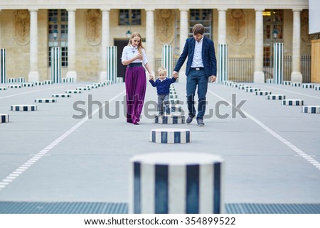 Happy family of three in the beautiful garden in Paris