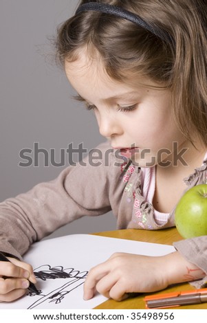 Girl drawing a picture with a green apple