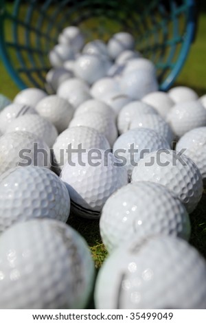 Golf balls pouring out of basket onto grass