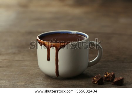 Cup of cacao with chocolate on wooden background