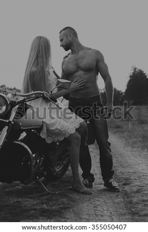 Black and white photo biker couple on a motorcycle in the field. Transferred passionate love photography. Beautiful and motorcycle accessories. Photo for motorcycle 