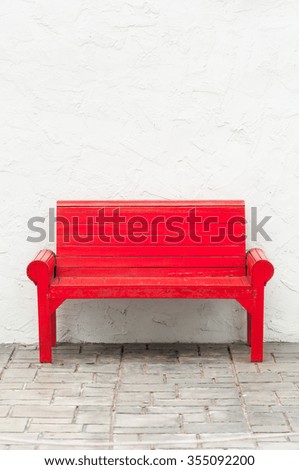 red wooden chair on concrete wall