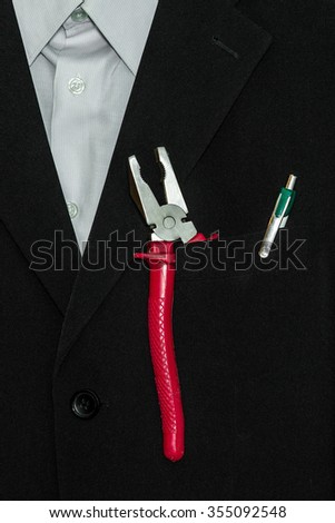 Big pliers tool in the pocket of an office suit. businessman and worker in one person