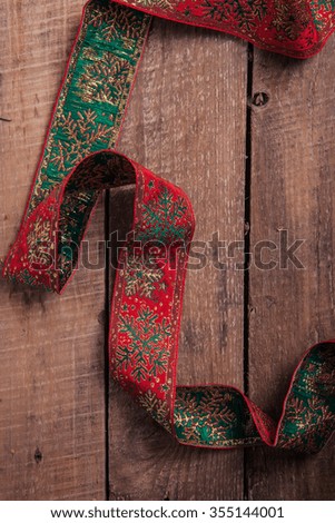 Red Christmas ribbon on a wooden background