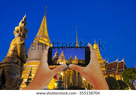 People taking pictures on mobile smartphone in Wat Phra Kaew in Bangkok, Thailand.