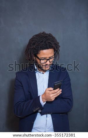 Casually handsome. Portrait of joyful young Arabic man standing against grey background. afro hair