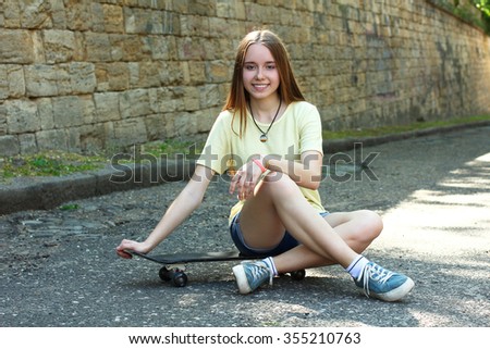 young girl with skateboard on the street