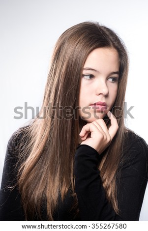 Studio portrait of a pensive teenage  girl on white background