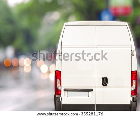 White delivery Van driving fast on city blurr bokeh street Royalty-Free Stock Photo #355281176