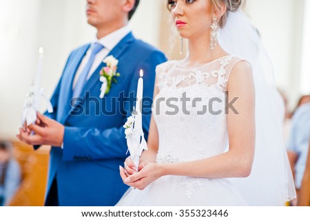 wedding couple on church with candle at hands
