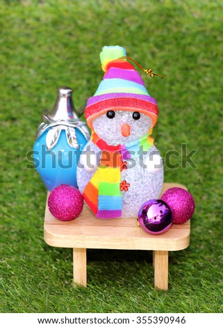 snow man on green grass with christmas decoration