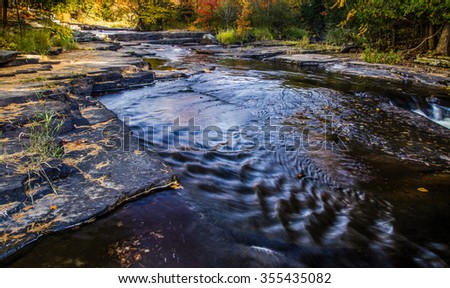 Autumn River Reflections. The colors of autumn reflected in the waters of a wilderness river at Canyon Falls  in Michigan's Upper Peninsula.