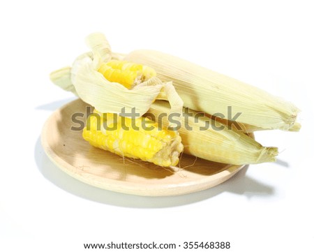 Boiled corn on a wooden plate, white background.