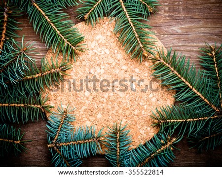 Christmas tree branch on a wooden table or board for background. New year theme. Toned.