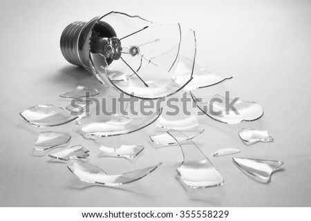 Broken light bulb and fragments on a white background Royalty-Free Stock Photo #355558229