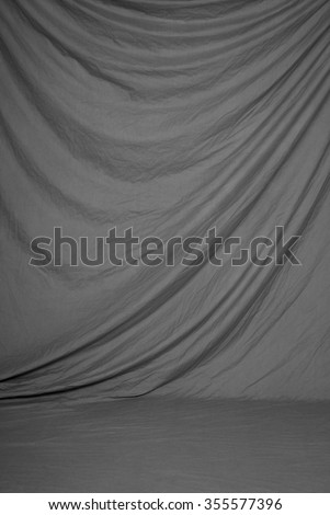 Traditional painted canvas or muslin fabric cloth studio backdrop or background, suitable for use with portraits, products and concepts. Classic, elegant, and neutral gray drape. Royalty-Free Stock Photo #355577396