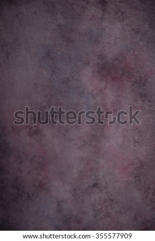 Traditional painted canvas or muslin fabric cloth studio backdrop or background, suitable for use with portraits, products and concepts. Dark purples with hints of magenta. Royalty-Free Stock Photo #355577909
