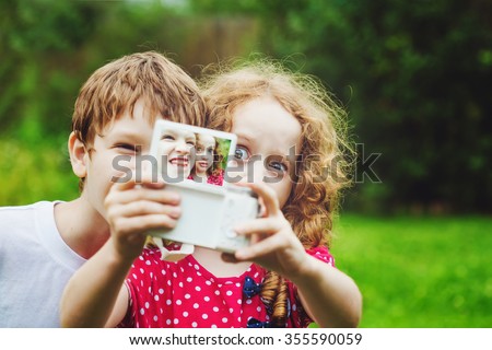 Children taking selfe with photo camera.