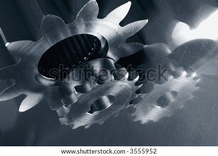 different gears in machinery in dark blue toning against aluminum