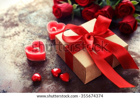 Valentine's Day, Gift box of kraft paper with a red ribbon and  candles. Rustic style Royalty-Free Stock Photo #355674374