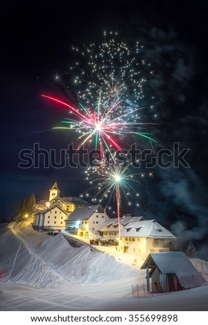 Panoramic night view of Monte Lussari, with fireworks idyllic mountain village in Italy
