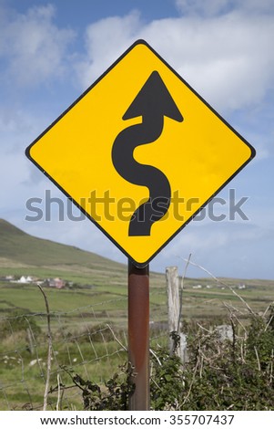 Curve Road Traffic Warning Sign in Village Setting