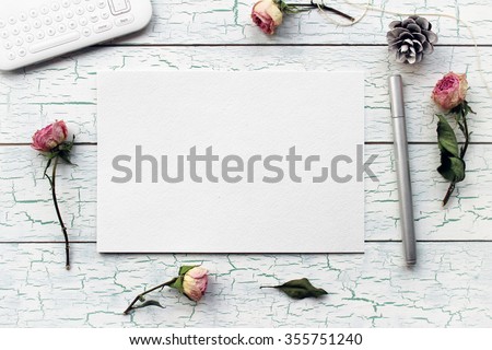Shabby chic, boho mockup for presentations with dry roses. Desktop workplace designer, artist, painter top view. Modern trend template for advertising.