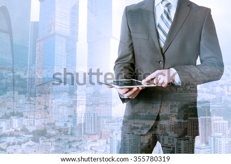Businessman using tablet on urban city background