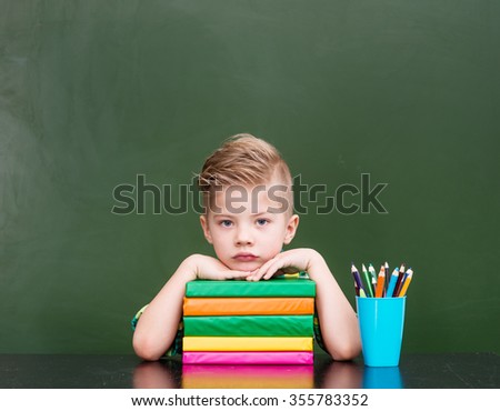 Tired schoolboy in classroom