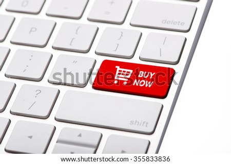 Closeup of buy now button on the keyboard. BUY NOW business concept, red shopping cart button or key on white keyboard photography.