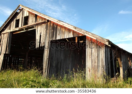 Evening light enhances the weathered wood grain on a rustic barn.