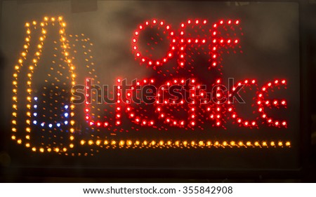 Off licence liquor store alcohol for sale neon light sign at night photo.