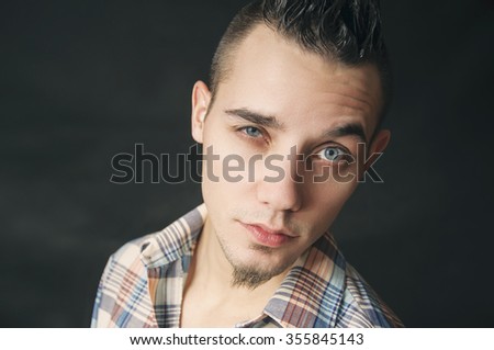 Portrait of a man with a plaid shirt on black background