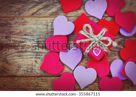 Valentine's Day background with gift box and hearts texture on old wooden table