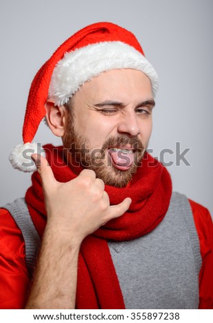 Business man showing call me in the winter. Corporate party, Christmas hat isolated portrait of a man on a gray background, studio photo.