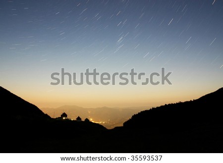 Stars raining over city at night. Long exposed picture.