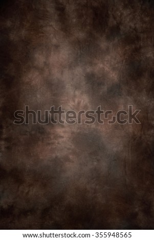 Painted canvas or muslin fabric cloth studio backdrop or background, suitable for use with portraits, products and concepts. Dark brown with red and orange warm tones. Royalty-Free Stock Photo #355948565