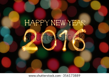 Happy New year 2016 written by sparklers firework with blurred colorful gold lights bokeh background