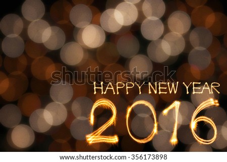 Happy New year 2016 written by sparklers firework with blurred gold lights bokeh background