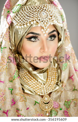 Portrait of a beautiful female model in traditional indian bridal costume with makeup and jewellery