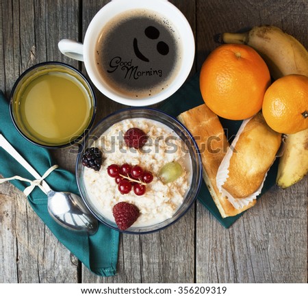Healthy breakfast. oatmeal with berries and glass of juice, cup of coffee, cakes and toasts on table. message Coffee - good morning  room for text. Toned image