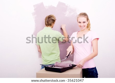happy young couple painting new home